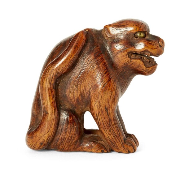 A Japanese wood netsuke, 19th century, carved as a growling dog with inlaid eyes, 4cm