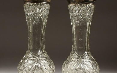 A PAIR OF CUT GLASS VASES with silver tops. 12ins