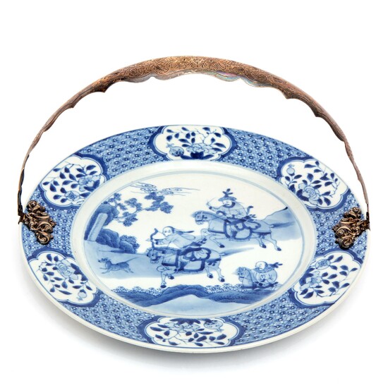 A blue and white plate with silver handle