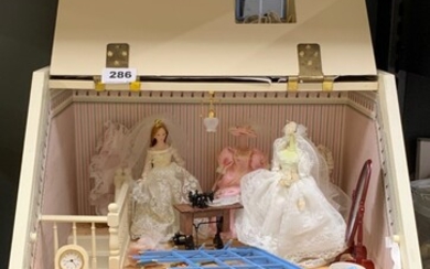 A dolls house complete bridal shop with mannequins, dresses, dolls, etc.