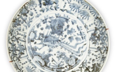 A large Chinese Swatow blue and white 'phoenix' charger, Ming dynasty, 16th century, painted to the central medallion with a phoenix among flowers and rocks, surrounded by a band of floral decoration separated by vertical lines, mounted with a...