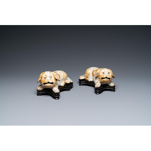 A pair of Chinese porcelain models of reclining dogs, Qianlo...