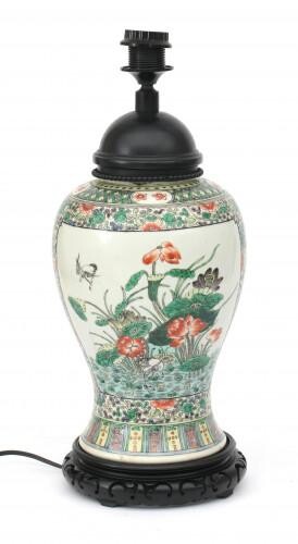 A wood mounted baluster shaped Chinese famille verte porcelain lamp foot with floral decoration, on carved wooden base.