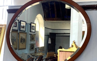 An Edwardian satinwood and mahogany framed oval wall mirror