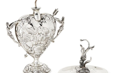 An Edwardian silver oil burner, London, 1901, William Comyns, the heart-shaped body decorated with winged putti and winged figural handles, 12.5cm high, base filled, together with a silver ashtray with stylised foliate handle and putti decorated...