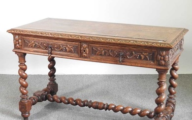 An early 20th century carved oak writing table, on spirally...