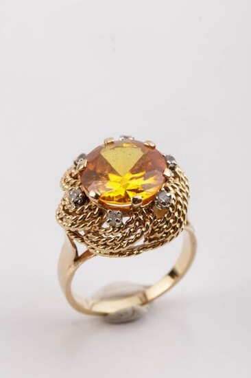 Gold ring set with a synthetic yellow sapphire...