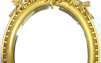 Miroir médaillon de style Louis XVI en bois sculpté, stuqué et doré, à décor d'oiseau...