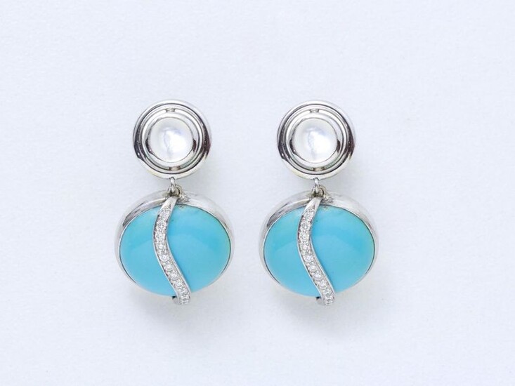 Pair of 750 thousandths white gold earrings holding in pendants a turquoise cabochon applied with an undulating line of brilliant-cut diamonds. The clasp is enhanced by a moonstone cabochon in a closed setting.
