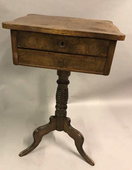 TABLE TRAVAILLEUSE en bois de plaque et loupe ouvrant à deux tiroirs et reposant sur des pieds tripodes