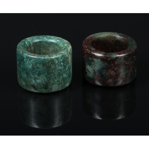 Two Chinese carved jade coloured hardstone archers rings, on...