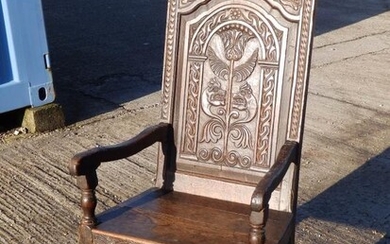 A 17thC carved oak open armchair, the back decorated...