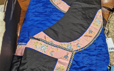A CHINESE QUILTED DEEP BLUE AND BLACK SILK JACKET EDGED WITH A PINK GROUND FLORAL BAND