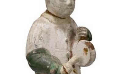 A Chinese pottery figure of an attendant, Ming dynasty, 16th century, modelled standing holding a drum, his robe partially glazed green, 31cm high