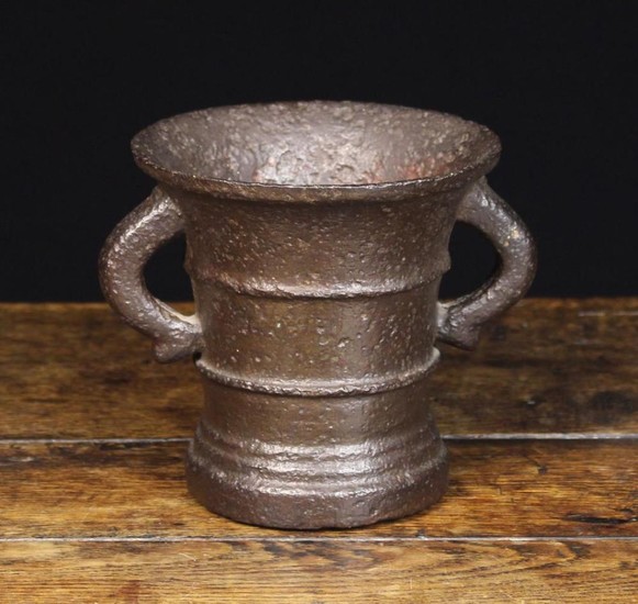 A Late 17th or Early 18th Century Cast Bronze Mortar. The heavily pitted flared body with raised rin