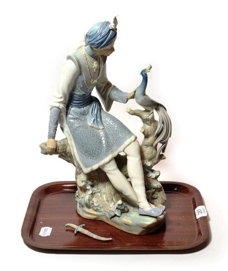 A Lladro model of an Indian figure and a peacock...