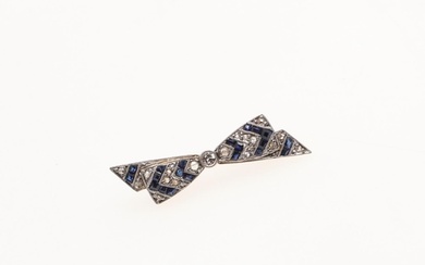 A SAPPHIRE AND DIAMOND BOW BROOCH. centred with a circular-c...