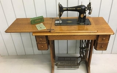 A Singer treadle sewing machine table with sewing machine,...