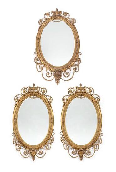 A Victorian Gilt and Gesso Oval Mirror, in Adam style, the oval bevelled glass plate within a...