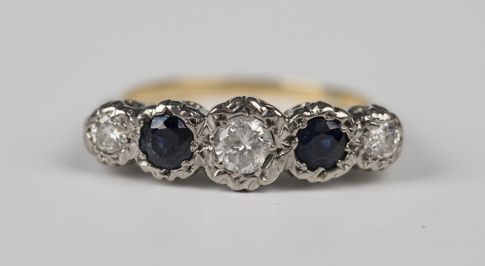 A gold and palladium, sapphire and diamond five stone ring, mounted with three circular cut diamonds
