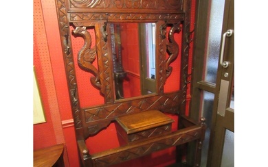 A late Victorian carved oak hall/stick stand with six coat h...