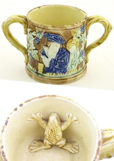 A majolica loving cup / twin handled mug decorated with