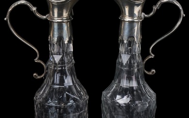 A pair of 19th century cut-glass flagons, with plated tops a...