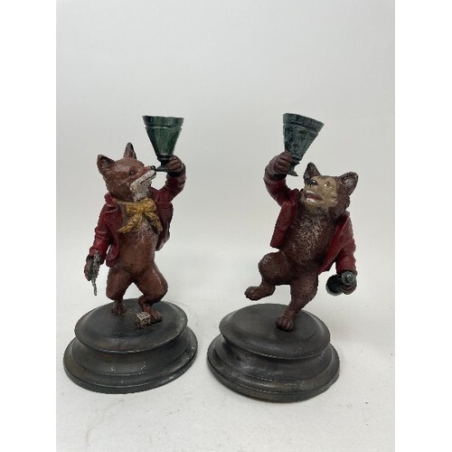 A pair of painted bronze candlesticks, in the form of a fox ...