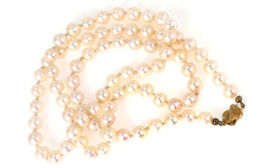 A pearl necklace set with numerous cultured pearls and a clasp of...