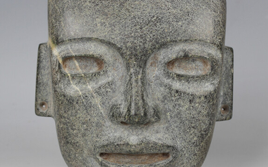 A pre-Columbian Teotihuacan style carved green hardstone mask, probably 250-700AD, with pierced ears
