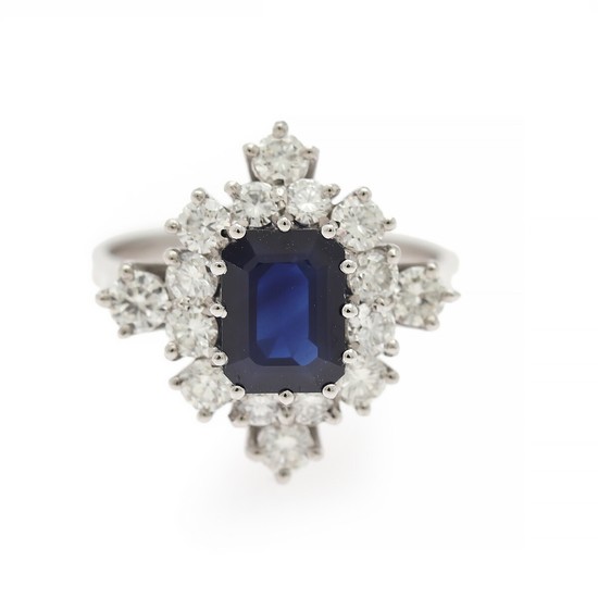 A sapphire and diamond ring set with a sapphire weighing app. 1.69 ct. encircled by numerous diamonds, mounted in 18k white gold. Size 54.