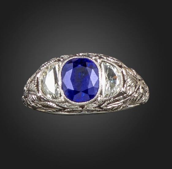 A sapphire and diamond three stone ring, the oval-shaped sapphire...