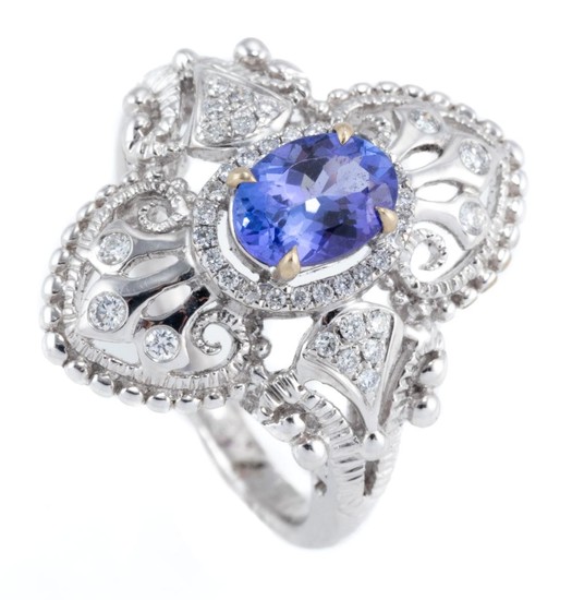AN 18CT WHITE GOLD TANZANITE AND DIAMOND RING; Edwardian inspired design centring an oval cut tanzanite of approx. 0.92ct to surroun...