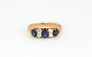 An antique yellow metal (tested high carat gold) ring set with oval cut sapphires and brilliant cut diamonds, (N).