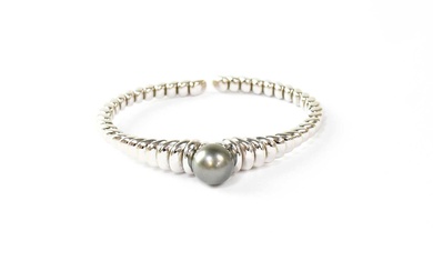 MAUBOUSSIN; an 18ct white gold beaded bangle, set with a...