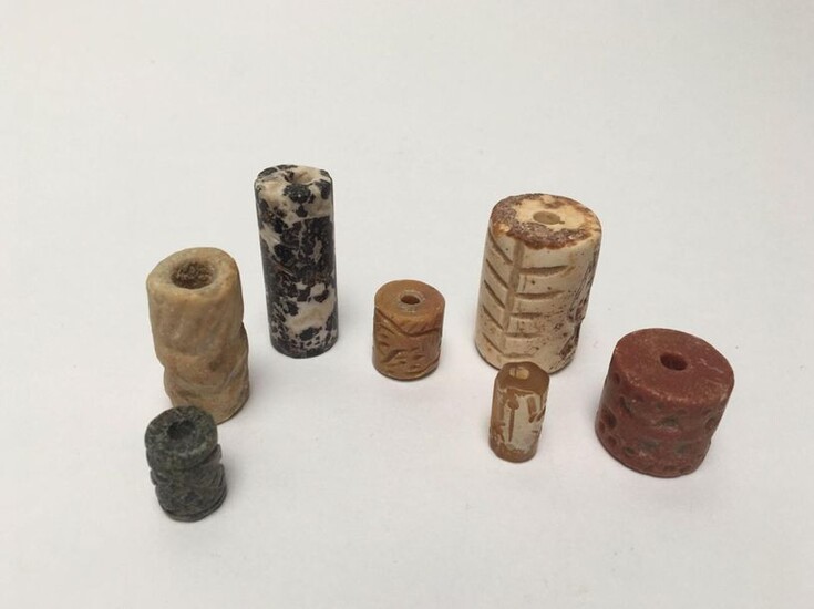 Set of seven engraved cylinder seals decorated with characters, animals, geometric figures...Hard stone, quartz and granite.
