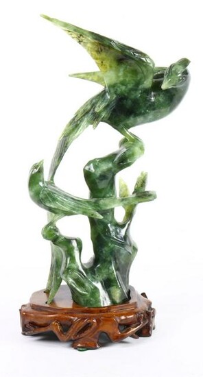Two carved spinach jade birds on wooden stand, one is
