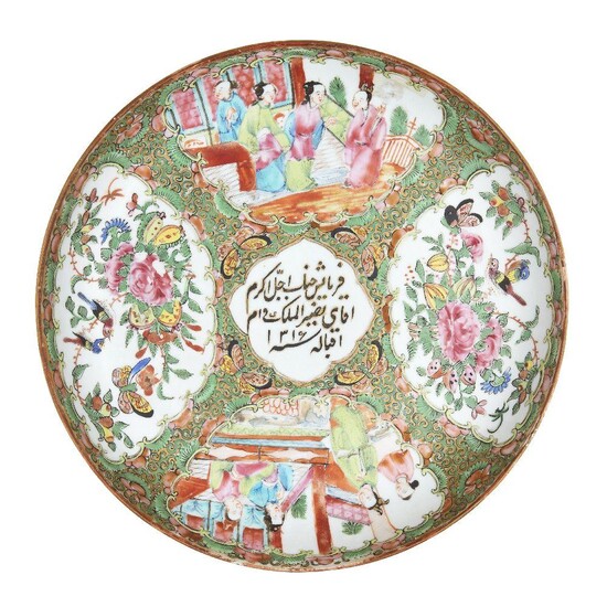 A Chinese Canton export porcelain dish for the Islamic market, late 19th century, painted in famille rose enamels with panels of figures in conversation and birds and butterflies amongst flowering peony blossoms, the central panel painted with an...
