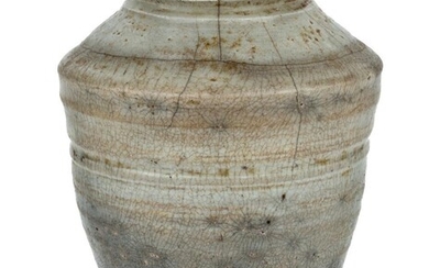 A Chinese crackle glaze jar, Ming dynasty, raised on a flat base, covered in grey glaze stopping above the foot, 18cm high 明 冰裂紋釉罐