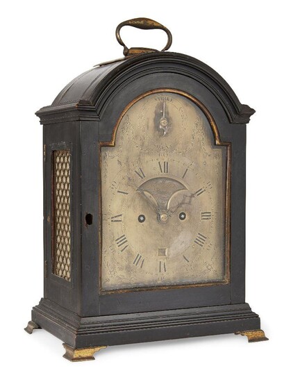 A George III ebonised twin fusee bracket clock, by John Montner, early 19th century, the ebonised case with broken arched cornice with brass swing handle, brass fish scale fretwork side panels and brass bracket feet, the arched brass dial with...