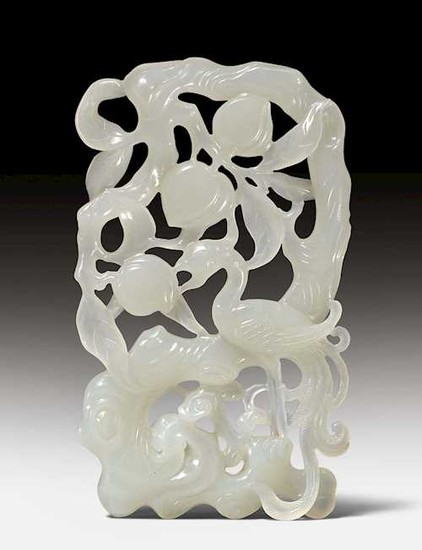 A WHITE JADE CARVING WITH A PHOENIX UNDER A PEACH TREE.
