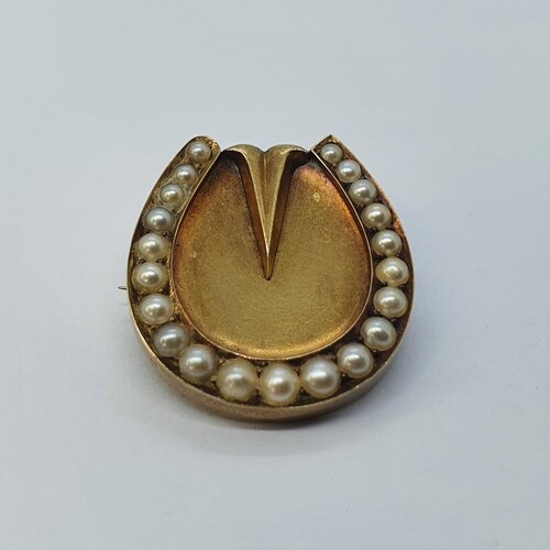 A gold horseshoe brooch, set with seed pearls, 2.5 cm high