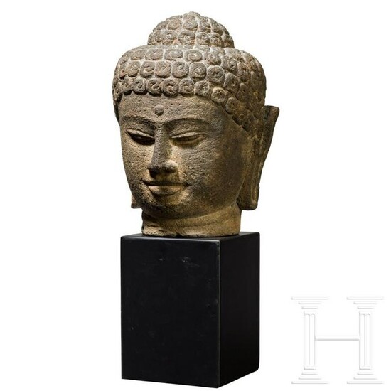 A large Javanese Buddha head carved in volcanic rock