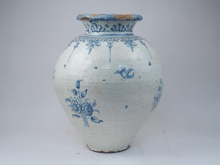 A large continental glazed terracotta vase, 19th century, decorated in blue and white with birds in flight and posies of flowers, 55cm high