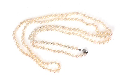 A long pearl necklace set with numerous Akoya pearls and a diamond...