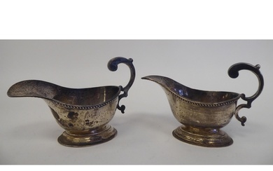 A pair of silver oval sauce boats, each with a gadrooned rim...