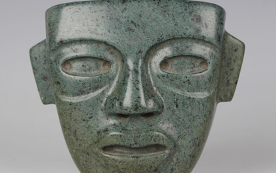 A pre-Columbian Teotihuacan style carved green hardstone mask, probably 250-700 AD, with pierced hol