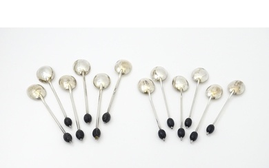 A set of six silver coffee spoons with coffee bean detail to...