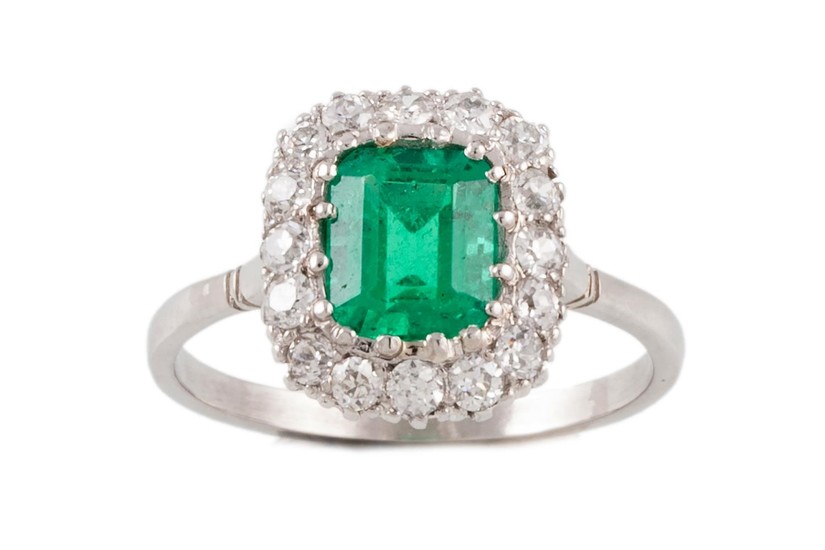 AN EMERALD AND DIAMOND CLUSTER RING, with one rectangular st...