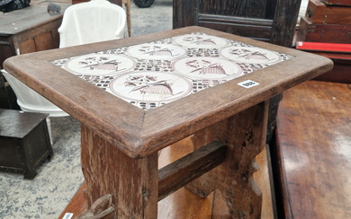 AN OAK COFFEE TABLE INSET WITH SIX DELFT MANGANESE TILES, THE PANEL LEGS PEGGED TO THE STRETCHER.
